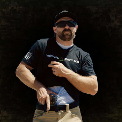 Man wearing an American Operator T-Shirt, showcasing a modern design and patriotic style while reaching for a concealed item.